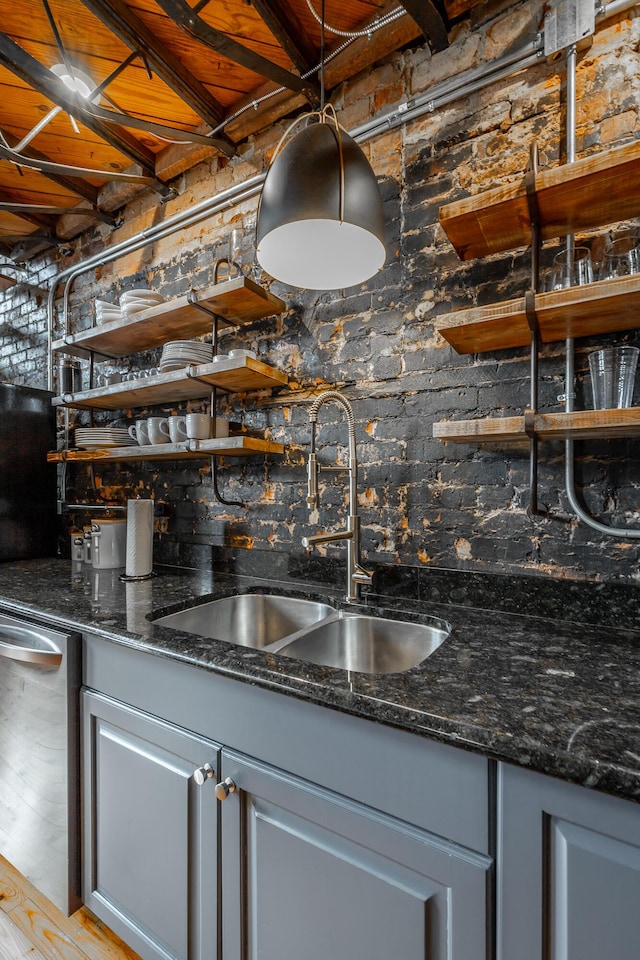 bar with stainless steel dishwasher, indoor wet bar, and a sink