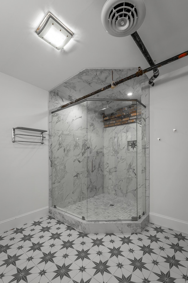 bathroom with a marble finish shower, visible vents, and tile patterned floors