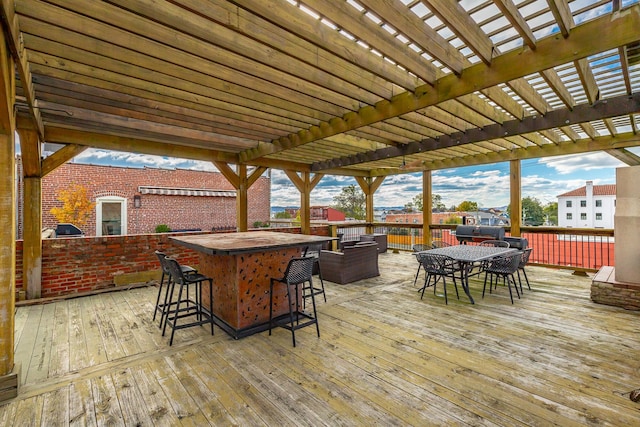 wooden terrace featuring outdoor dry bar, outdoor dining area, and a pergola