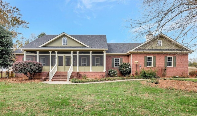 view of front of home with a sunroom and a front yard