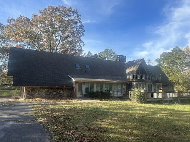 back of property featuring a lawn and a balcony