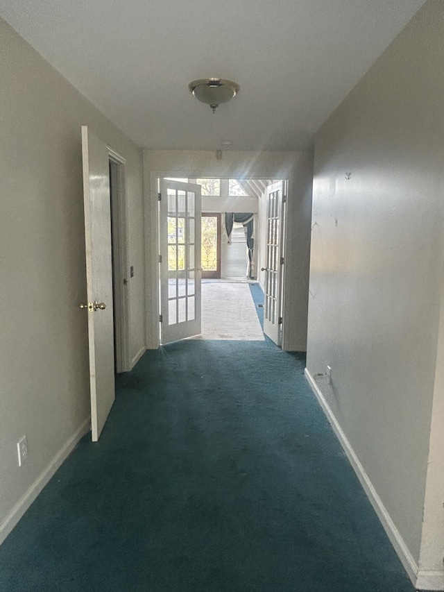 hall featuring french doors and dark colored carpet