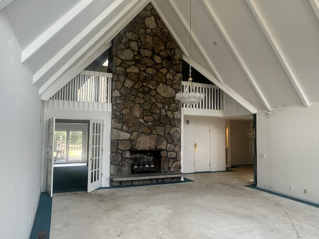 unfurnished living room with a fireplace, high vaulted ceiling, and beamed ceiling