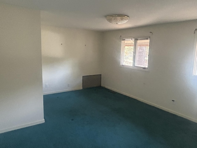 unfurnished room featuring dark colored carpet