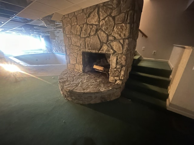 interior space with a paneled ceiling and a fireplace