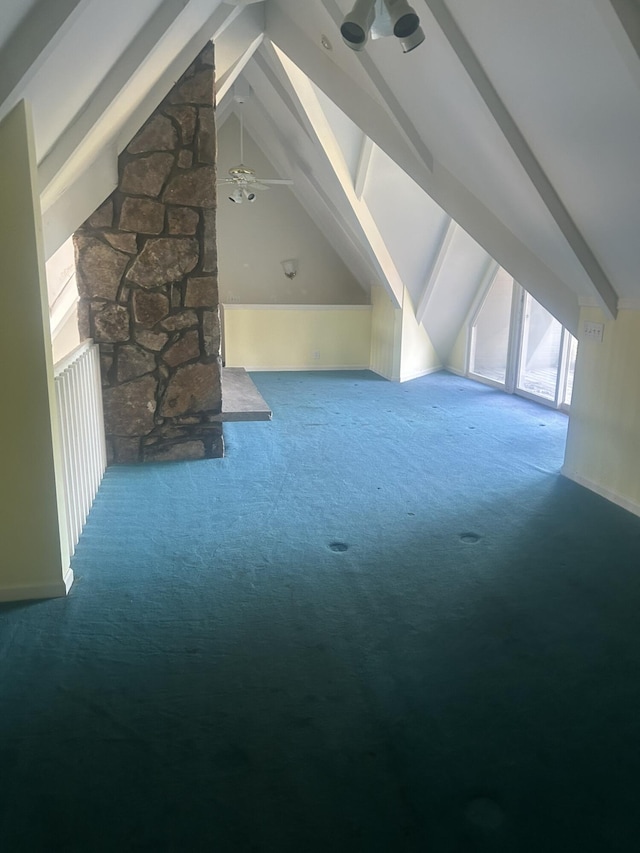 bonus room with ceiling fan, beam ceiling, a stone fireplace, and carpet floors