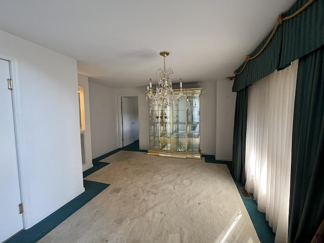 unfurnished dining area with a chandelier and dark carpet