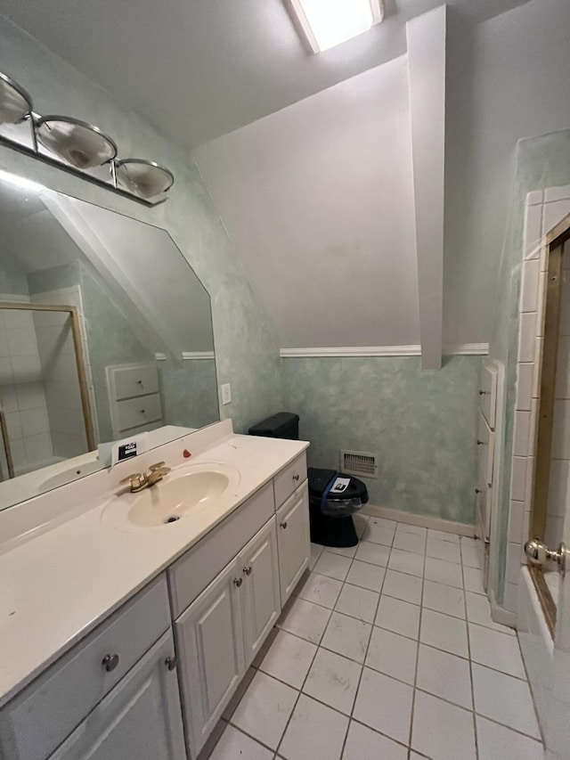 bathroom featuring vanity, tile patterned floors, walk in shower, and lofted ceiling