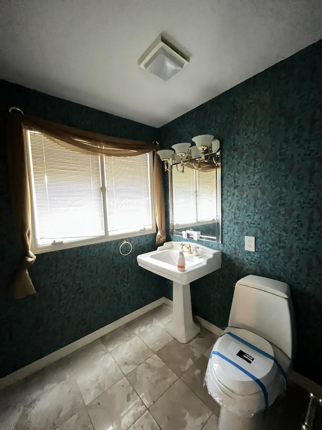 bathroom featuring a healthy amount of sunlight, toilet, and sink