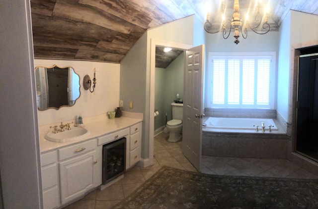 bathroom featuring vanity, vaulted ceiling, toilet, tiled tub, and a notable chandelier