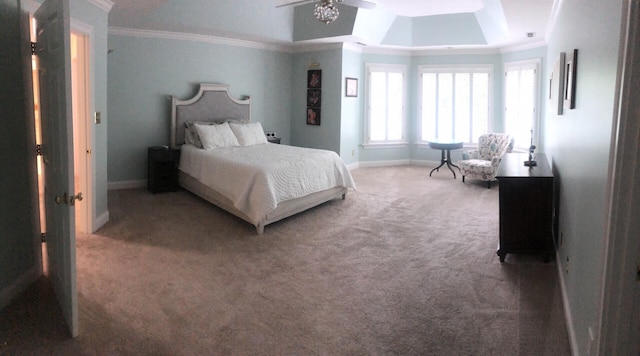 carpeted bedroom with a raised ceiling, ceiling fan, and crown molding