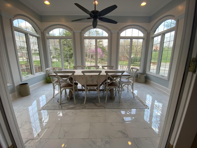 sunroom featuring ceiling fan and plenty of natural light