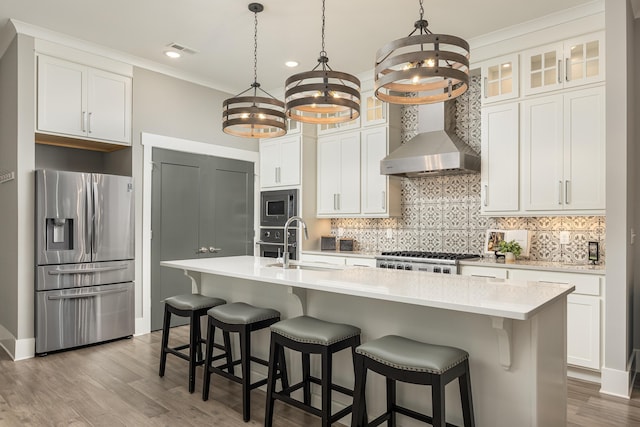 kitchen with a kitchen island with sink, white cabinets, appliances with stainless steel finishes, and a chandelier