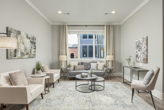 sitting room with wood-type flooring and ornamental molding