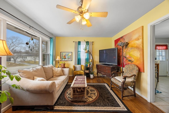 living room featuring plenty of natural light, ceiling fan, and wood-type flooring