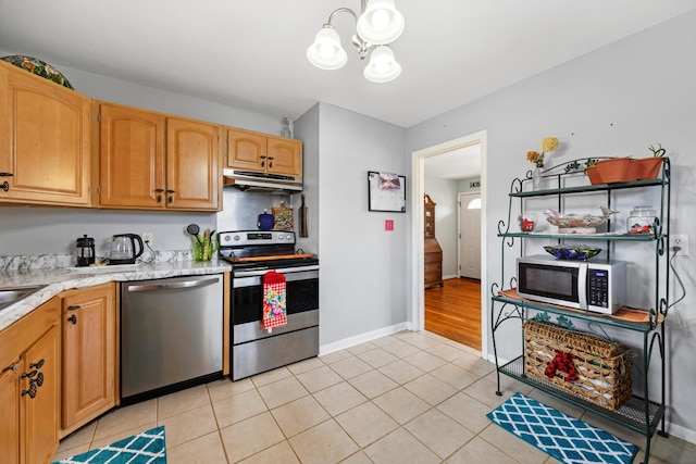 kitchen with a chandelier, appliances with stainless steel finishes, and light tile patterned floors