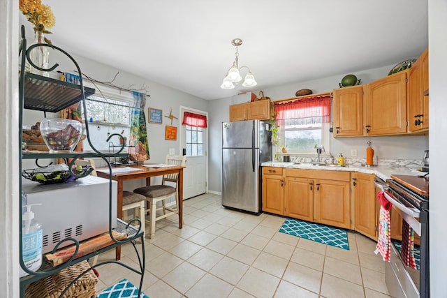 kitchen with sink, stainless steel appliances, a chandelier, decorative light fixtures, and light tile patterned floors