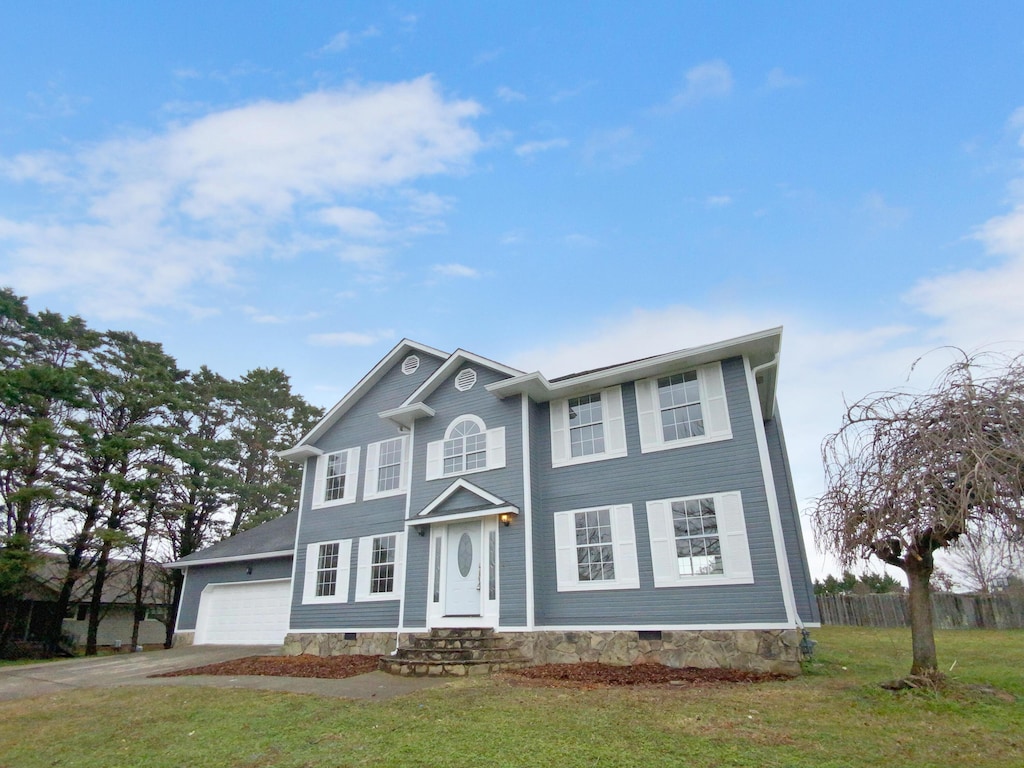 view of front of home with a front yard and a garage