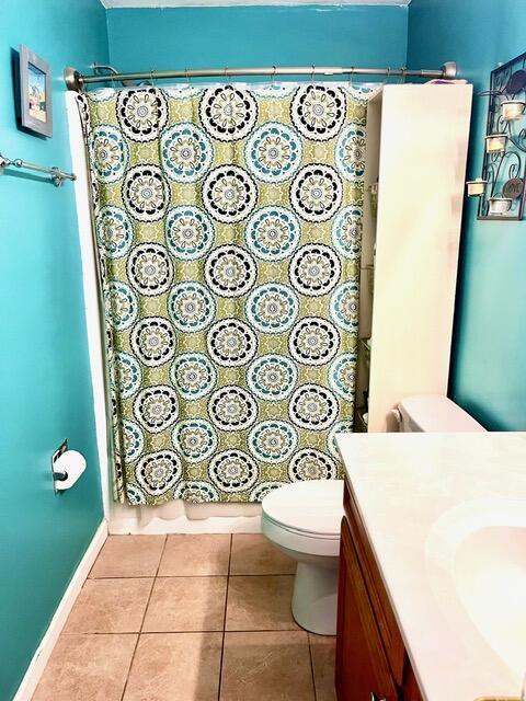 bathroom with tile patterned flooring, vanity, toilet, and a shower with curtain