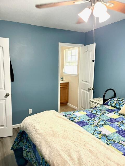 bedroom featuring ensuite bath, ceiling fan, and hardwood / wood-style floors