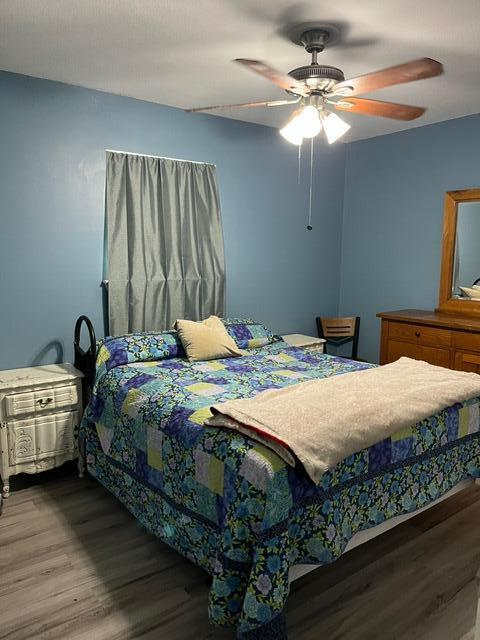 bedroom with hardwood / wood-style flooring and ceiling fan