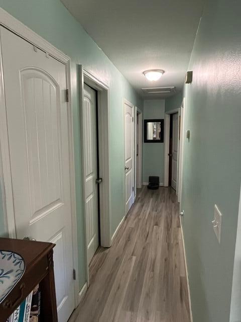 corridor with light hardwood / wood-style flooring