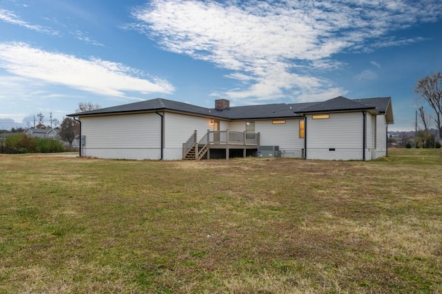 back of property with a lawn, a wooden deck, and central AC