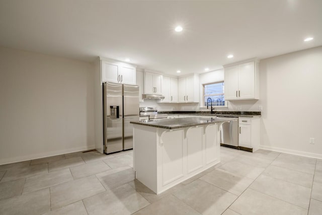 kitchen featuring appliances with stainless steel finishes, a center island, white cabinetry, and sink