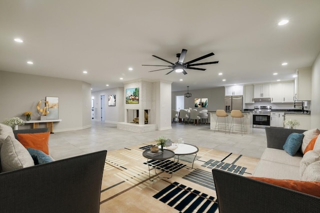 tiled living room with ceiling fan and a brick fireplace