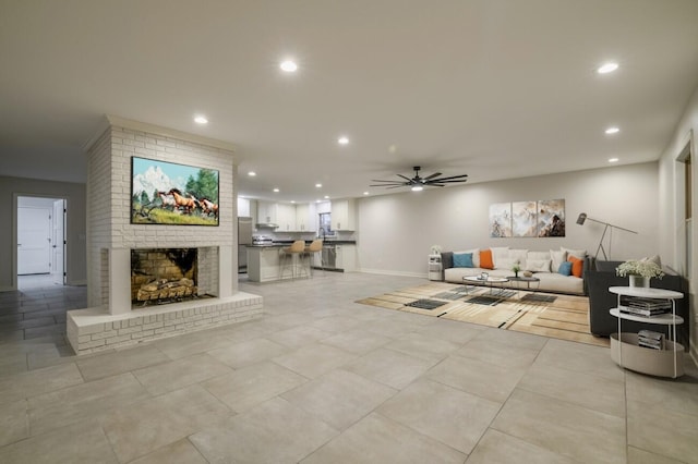 living room with ceiling fan and a fireplace