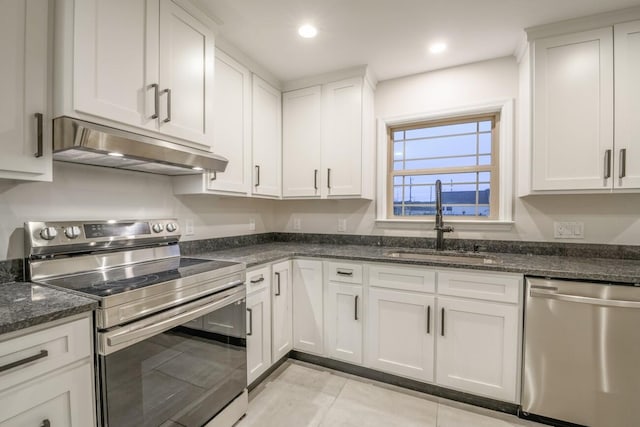 kitchen with white cabinetry, sink, appliances with stainless steel finishes, and dark stone counters