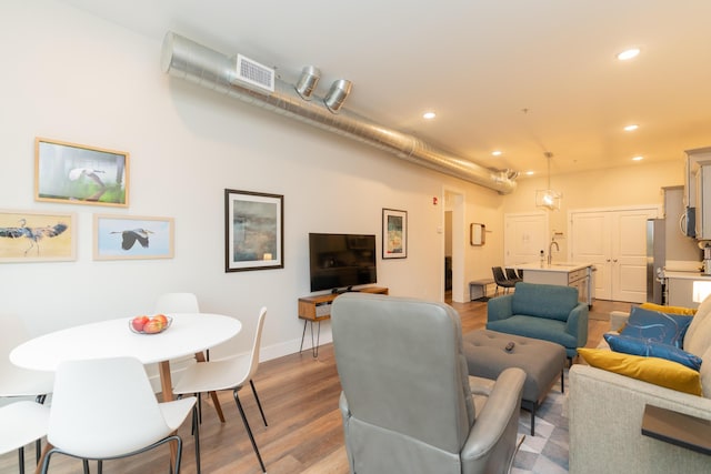 living room featuring light hardwood / wood-style flooring and sink