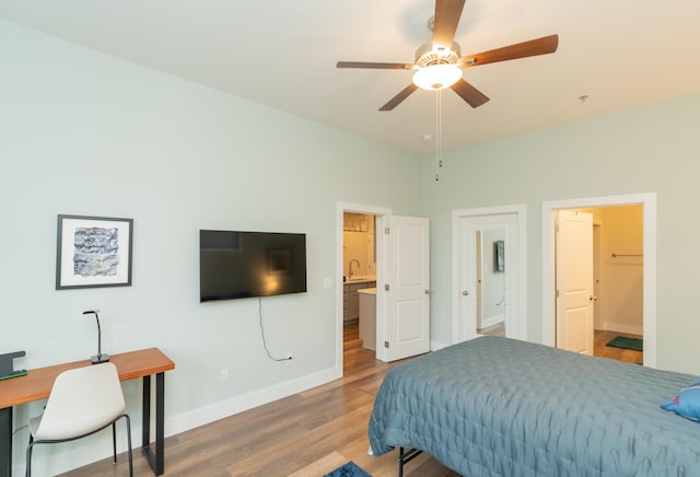 bedroom featuring connected bathroom, ceiling fan, sink, and wood-type flooring