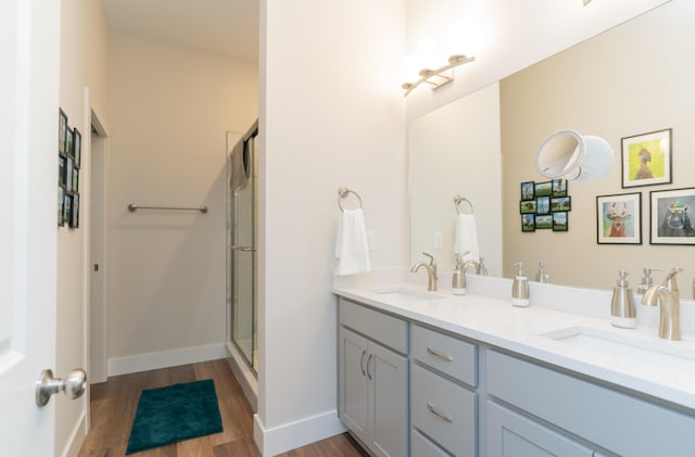 bathroom featuring hardwood / wood-style floors, vanity, and walk in shower