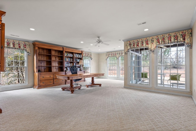 unfurnished office featuring carpet floors, ceiling fan, and crown molding