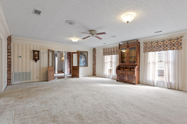 unfurnished living room featuring ceiling fan, a healthy amount of sunlight, and ornamental molding