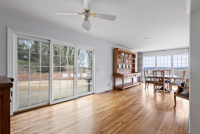 dining space featuring light hardwood / wood-style flooring, ceiling fan, and ornamental molding