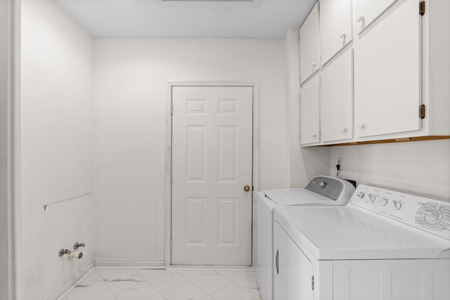 laundry area featuring washing machine and clothes dryer and cabinets