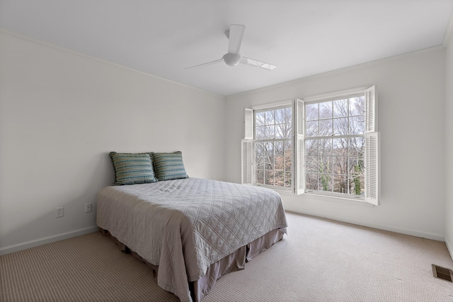 bedroom with ceiling fan, crown molding, and light carpet