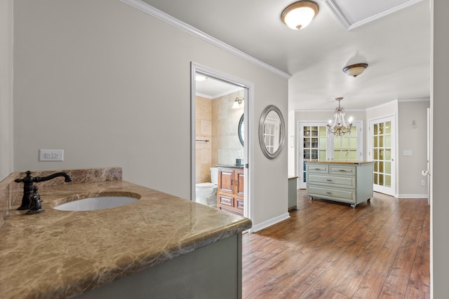 bathroom featuring vanity, crown molding, toilet, wood-type flooring, and a chandelier