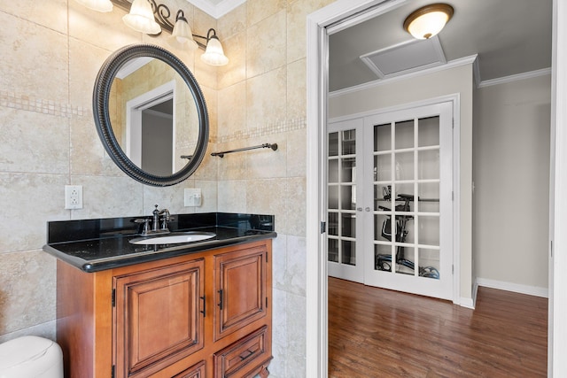 bathroom with decorative backsplash, vanity, crown molding, wood-type flooring, and tile walls