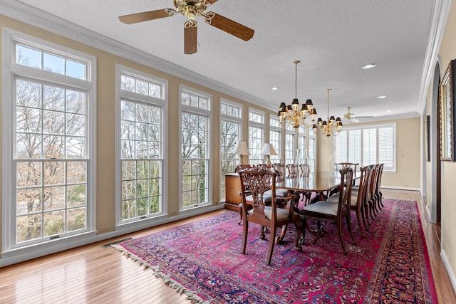 dining space featuring hardwood / wood-style floors, a textured ceiling, and ornamental molding