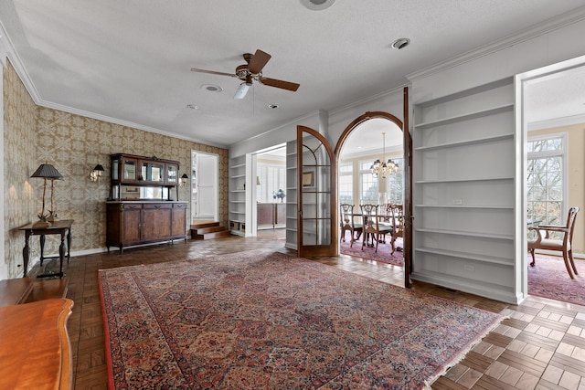 unfurnished living room with ceiling fan with notable chandelier, dark parquet floors, built in shelves, ornamental molding, and a textured ceiling