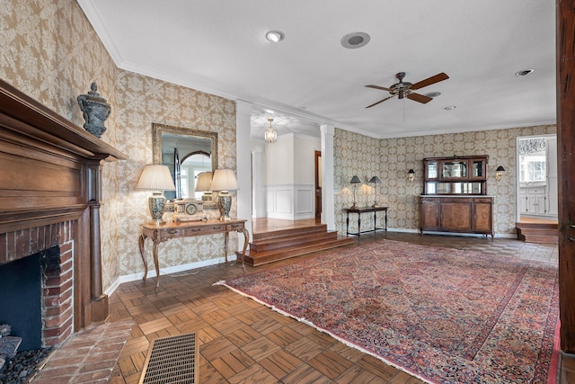 unfurnished living room featuring ceiling fan, dark parquet flooring, ornamental molding, and a fireplace