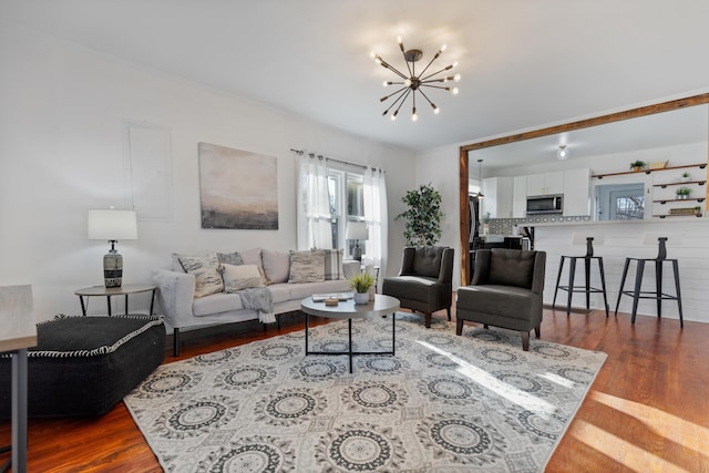 living room with hardwood / wood-style floors and a notable chandelier