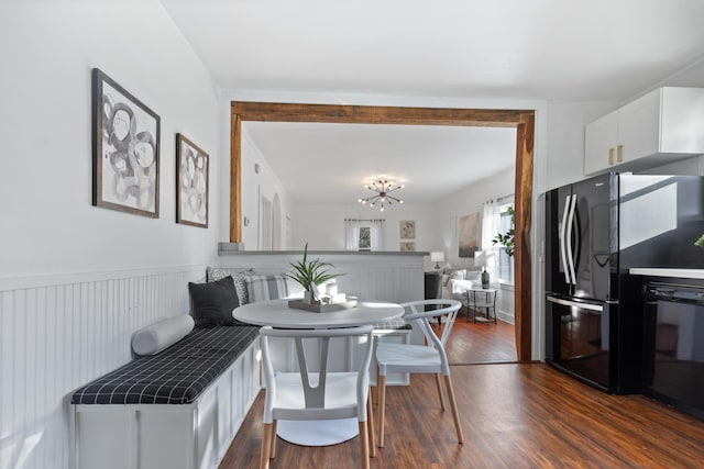 dining space featuring dark wood-type flooring and a chandelier