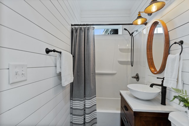 bathroom featuring vanity, wood walls, and shower / bath combo with shower curtain