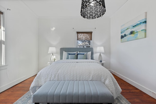 bedroom with ornamental molding and hardwood / wood-style flooring