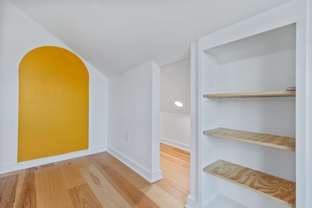 interior space with hardwood / wood-style flooring and vaulted ceiling