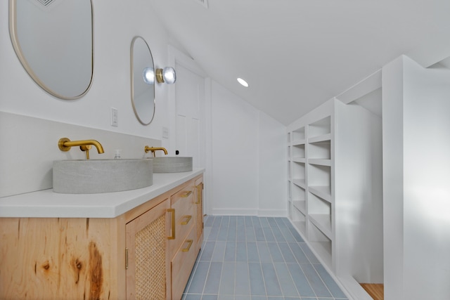 bathroom featuring built in features, vanity, and vaulted ceiling